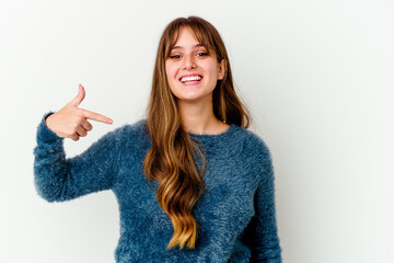 Wall Mural - Young caucasian cute woman isolated on white background person pointing by hand to a shirt copy space, proud and confident