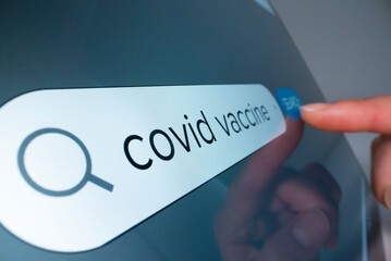Wall Mural - Close-up view of searching information on COVID 19 vaccine on the internet, shot with macro probe lens