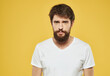 © SHOTPRIME STUDIO - Portrait of a sad man on a yellow background cropped view of a white t-shirt
