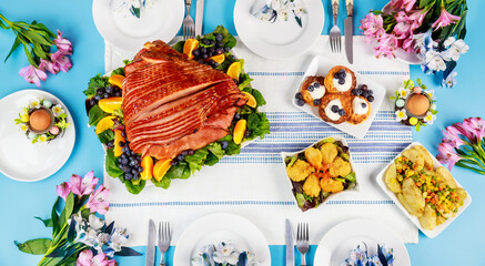 Festive Easter table with ham, salad and pancakes.