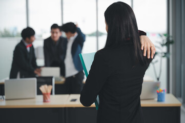 Wall Mural - Confident and smart beautiful businesswoman in formal attire stands in the office. With a group of friends and laptop in the background. A cheerful idea to work within the workspace.