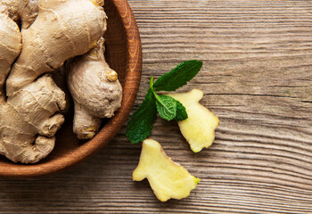 Wall Mural - Bowl with fresh ginger on wooden table