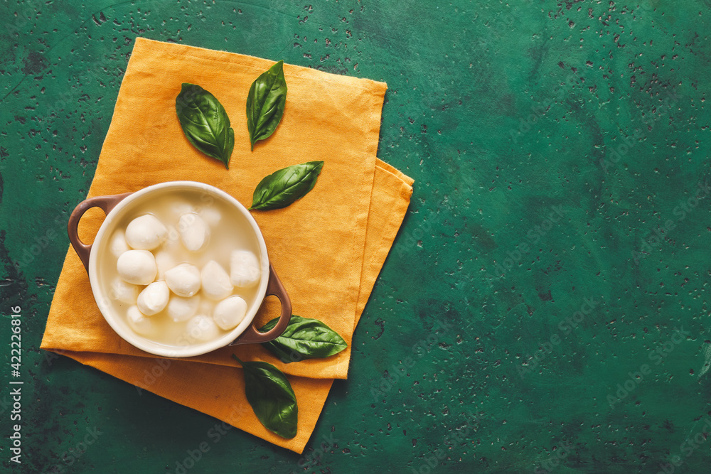 Cooking pot with mozzarella cheese on color background