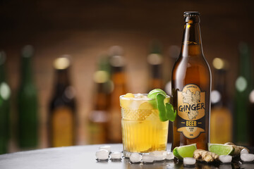 Wall Mural - Bottle and glass of fresh ginger beer on table in pub