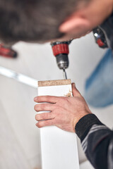 Wall Mural - Handyman worker assembling furniture and fixing it.