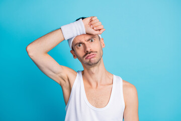 Sticker - Photo of tired young man hold hand head exhausted exercise workout in gym isolated on blue color background