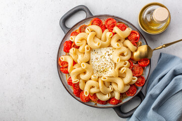 Poster - Cooking baked feta pasta. Cooked pasta with baked feta cheese, and cherry tomatoes, before mixing the ingredients. Top view.