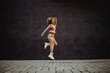 © Dusan Petkovic - Full length of cheerful hip hop girl in tracksuit jumping in place.