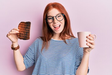 Wall Mural - Young red head girl holding burned toast for breakfast celebrating crazy and amazed for success with open eyes screaming excited.