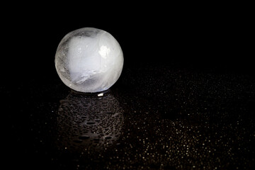 Wall Mural - ice ball reflection on black background.