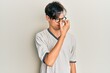 © Krakenimages.com - Young hispanic man wearing casual clothes and glasses tired rubbing nose and eyes feeling fatigue and headache. stress and frustration concept.