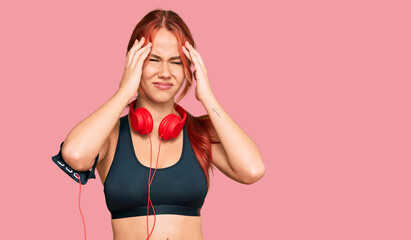 Sticker - Young redhead woman wearing gym clothes and using headphones suffering from headache desperate and stressed because pain and migraine. hands on head.