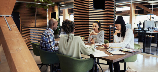 Wall Mural - Young businesspeople working around a table