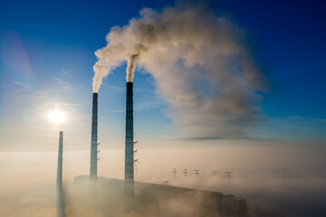 Canvas Print - Aerial view of coal power plant high pipes with black smoke moving up polluting atmosphere at sunset.