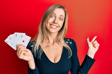 Poster - Beautiful caucasian woman holding ace poker cards smiling happy pointing with hand and finger to the side