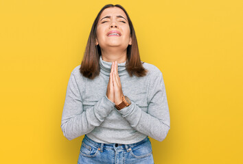 Sticker - Young beautiful woman wearing casual turtleneck sweater begging and praying with hands together with hope expression on face very emotional and worried. begging.