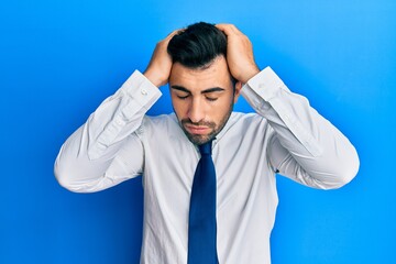 Wall Mural - Young hispanic man wearing business clothes suffering from headache desperate and stressed because pain and migraine. hands on head.