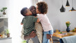 © Halfpoint - Small children kissing father at home, multi ethnic family.