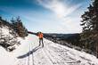 Langläufer Wintersport mit orangener Jacke Skisport