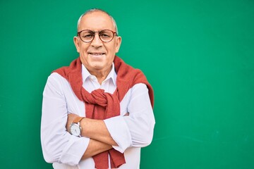 Wall Mural - senior man smiling happy wearing glasses walking at the city.