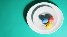 Banner Colorful Eggs On A Plate, Bright Green Blue Background, Easter Concept