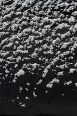 Wet snow on black glass. Natural texture for background.