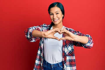 Wall Mural - Beautiful hispanic woman wearing casual clothes smiling in love doing heart symbol shape with hands. romantic concept.