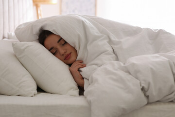 Sticker - Young woman covered with warm white blanket sleeping in bed at home