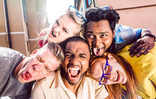 Multiracial Millenial People Taking Selfie Sticking Out Tongue With Happy Faces - Funny Life Style Concept Against Racism With International Young Friends Having Fun Together - Warm Bright Filter