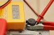 © Ilya - Car battery positive pin with red terminal cleat on digital multimeter volt meter screen with 12.74 volts digit backgroung closeup, full charged plumbic car battery