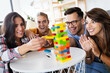 © NDABCREATIVITY - Happy group of friends have fun and playing board game together