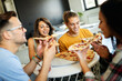 © NDABCREATIVITY - Spending time with friends. Group of cheerful young people talking and eating pizza together