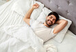 © Prostock-studio - Wellslept arab man waking up and smiling, enjoying good morning in bed