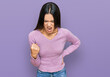 Young hispanic girl wearing casual clothes angry and mad raising fist frustrated and furious while shouting with anger. rage and aggressive concept.