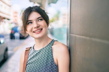 Sticker - Young caucasian businesswoman smiling happy leaning on the wall at the city.