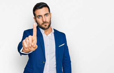 Canvas Print - Young hispanic man wearing business jacket pointing with finger up and angry expression, showing no gesture