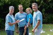 © wavebreak3 - Caucasian senior couple with father and son in volunteer shirts smiling in littered field