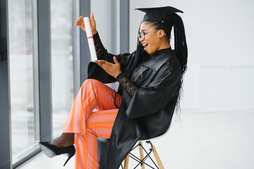 cheerful african american graduate student with diploma in her hand