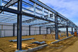 © Tom - Steel frame commercial building under construction for expanding local business in urban area.