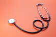© Qwenergy - Blue medical stethoscope on orange background. Close-up