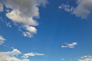 Wall Mural - dramatic blue sky with rays and white clouds