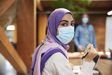 Poster - Muslim businesswoman wearing a face mask in a meeting