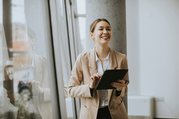 Wall Mural - Young woman holding digital tablet in modern office