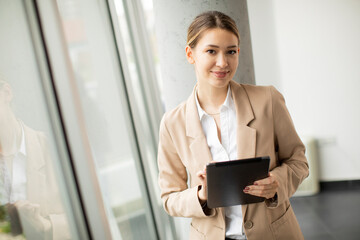 Wall Mural - Young woman holding digital tablet in modern office