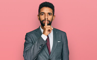 Wall Mural - Young african american man wearing business clothes asking to be quiet with finger on lips. silence and secret concept.