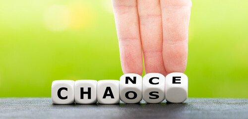 Wall Mural - Hand turns dice and changes the word chaos to chance.