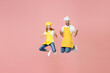 Full length teen fun girl dad father's helper chef cook confectioner baker in yellow apron cap jump high doing winner gesture clench fist celebrate isolated on pastel pink background studio portrait
