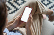 © insta_photos - Young woman or teen girl hands holding mobile smart phone with mockup white blank display, empty screen at home. Shopping, delivery apps, social media applications ads, over shoulder close up view.