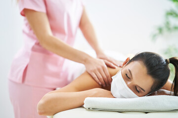 Wall Mural - Adult woman in mask during relaxing massage in spa