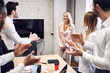 © Roman - Concentrated business people applaud their colleague after the presentation in the board room